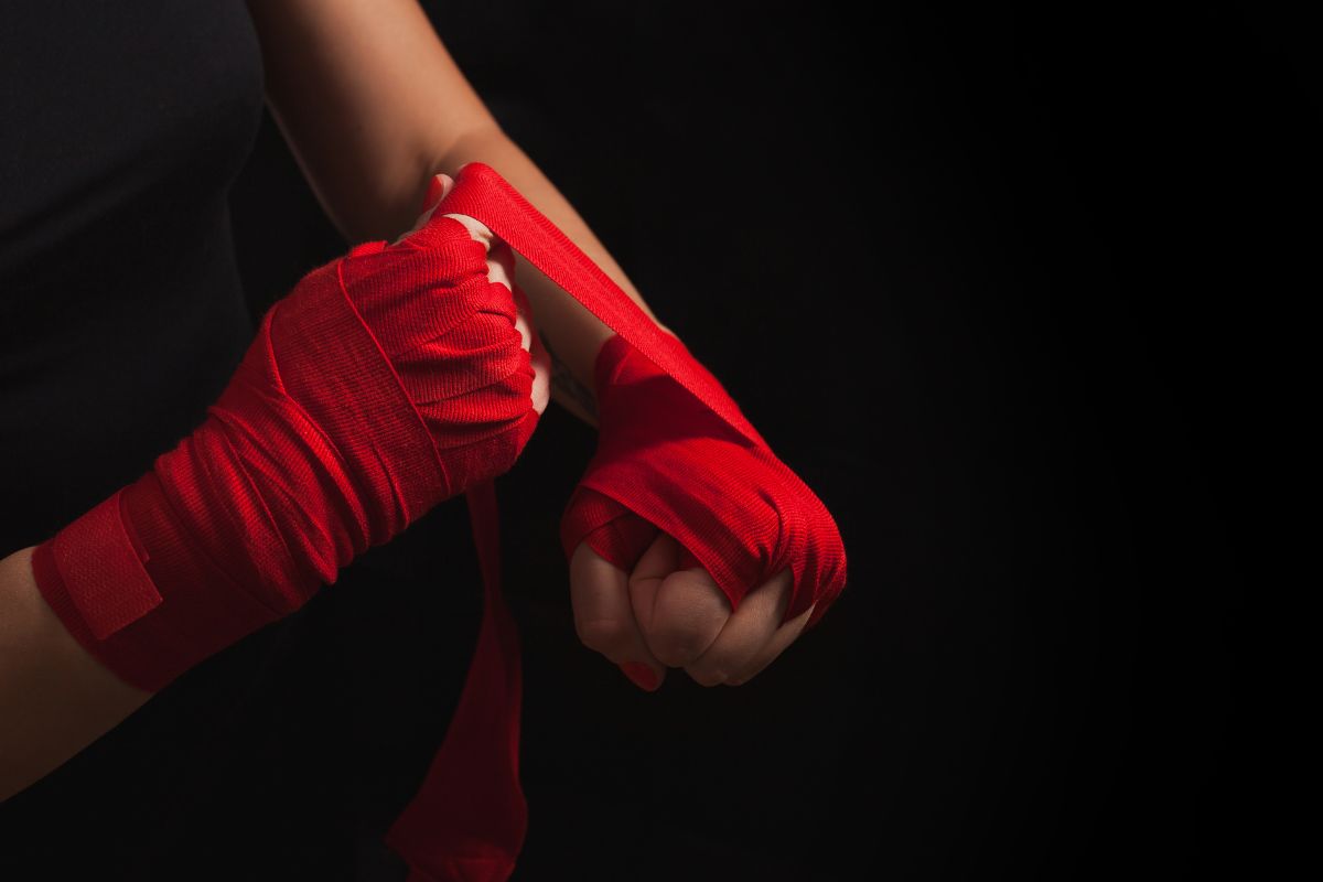Female boxer wrapping hands with wraps